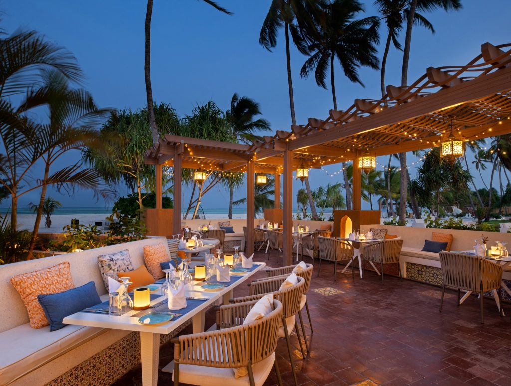 Außenterrasse des Lux Marijani Restaurants mit Terrakottaboden, gedeckten Tischen und Meer im Hintergrund