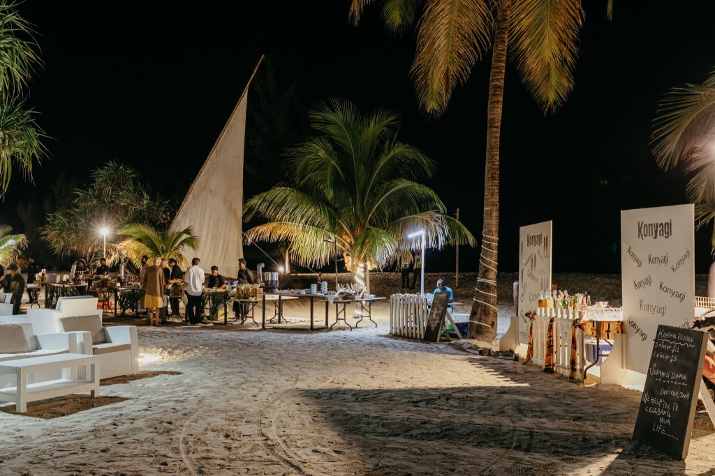 Nächtlicher Strandbereich mit hellem Rattanmobiliar und Buffet im Lux Marijani restaurant-horizon auf Sansibar