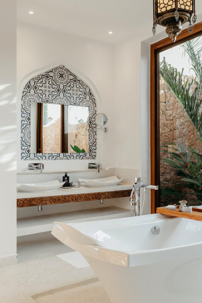 Badezimmer im Lux Marijani mit freistehendem Waschbecken, großer Badewanne, orientalischen Fliesen und Fenster mit Blick.
