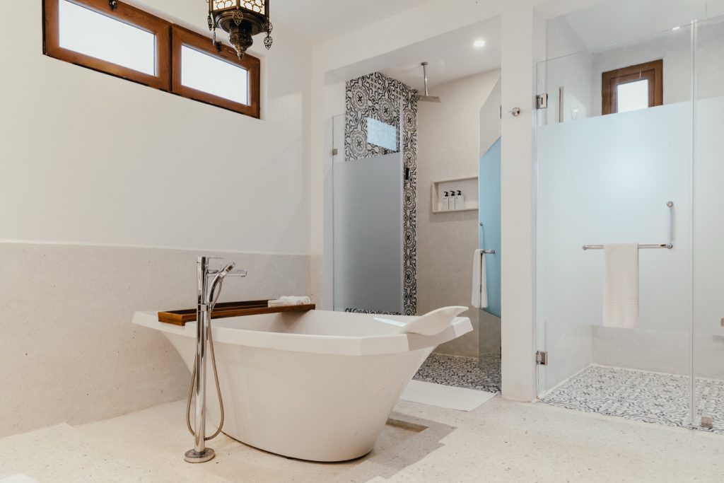 modernes Badezimmer im Lux Marijani Executive Room mit weißer freistehender Badewanne, Glasdusche und hellen Fliesen