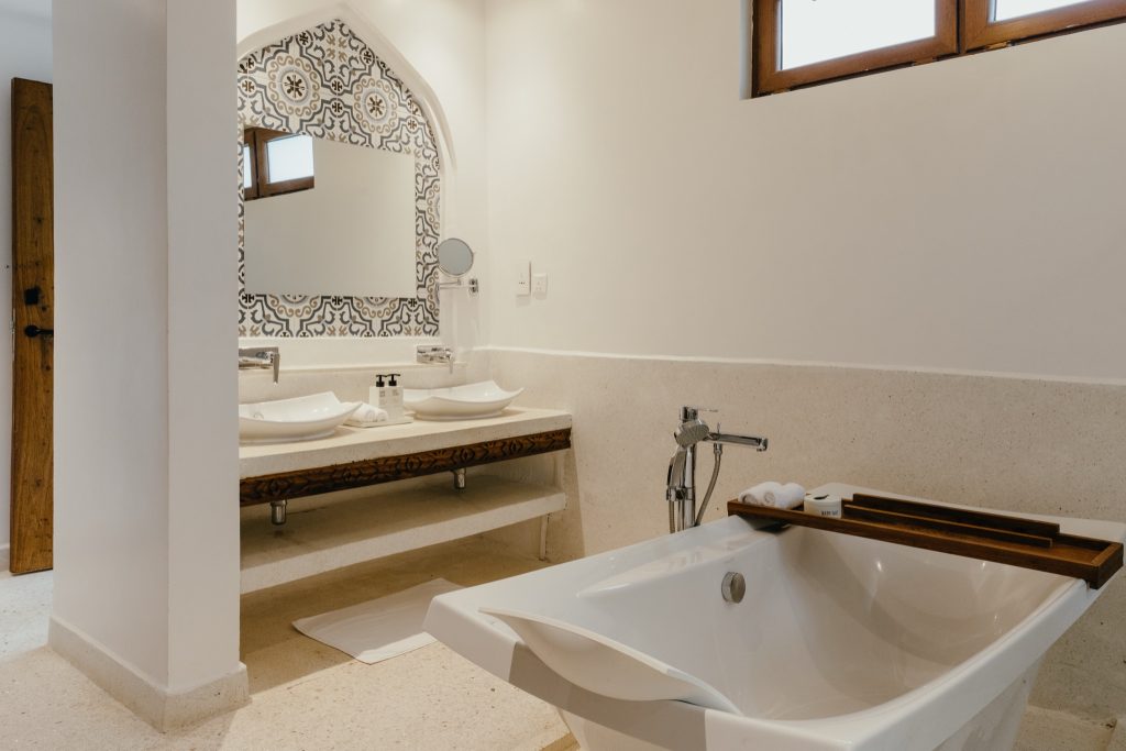 Badezimmer im Lux Marijani Executive Room mit freistehender Badewanne, Doppelwaschtisch und schwarz-weiß gemusterten Fliesen
