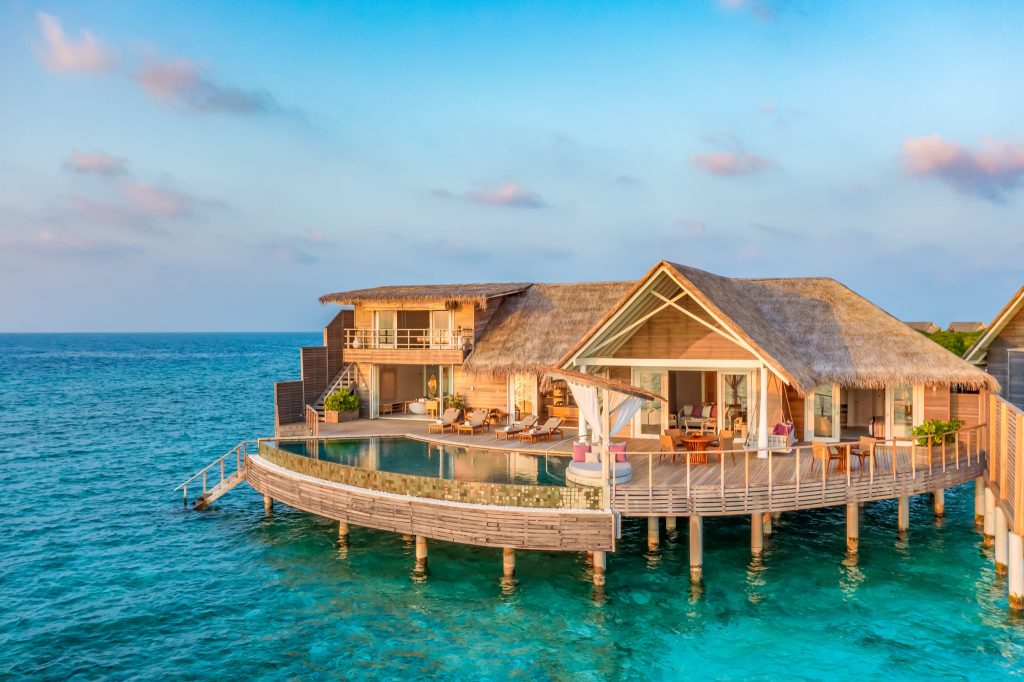Überwasser-Bungalow der Ocean Residence auf Milaidhoo Island mit Holzstruktur und Stroh-Dach über türkisblauem Meer