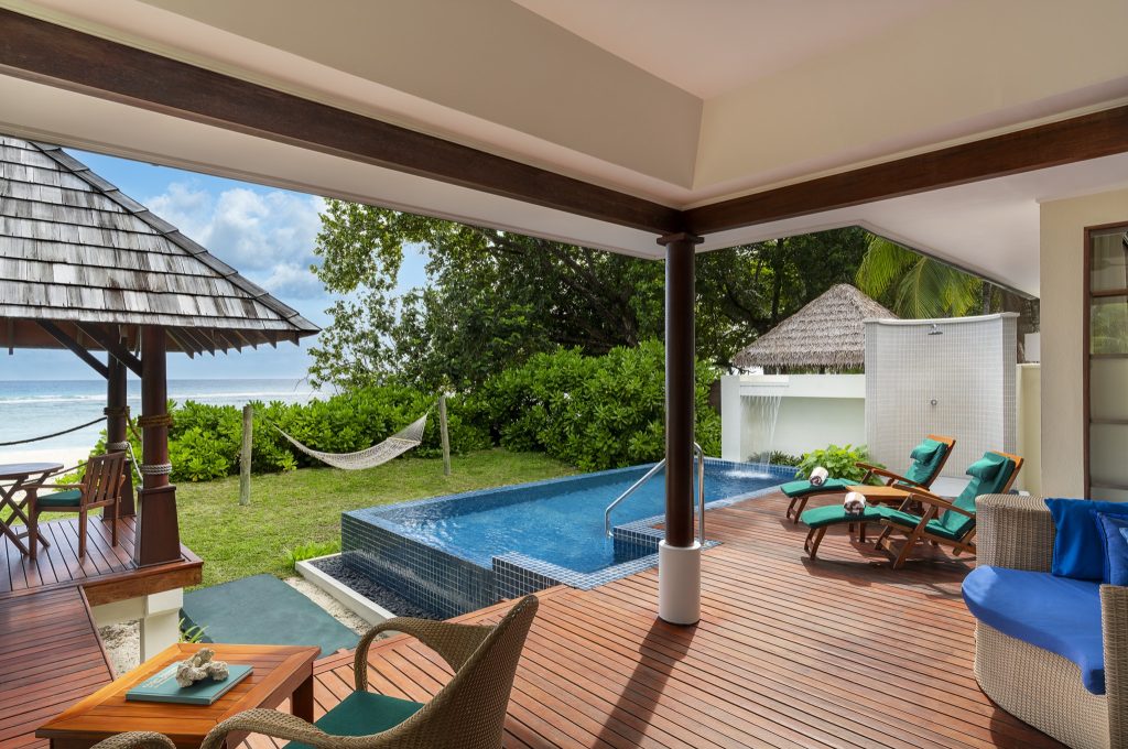 Terrasse eines Beach Sanctuary Pool Zimmers mit Holzveranda, Privatpool, Liegestühlen und Pavillon am Strand