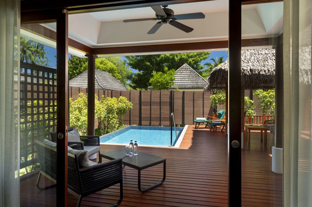 Hotelterrasse mit privatem Pool, Holzfußboden, schwarzen Stühlen und Strohdach-Liegestühlen in NIVA Labriz Seychelles