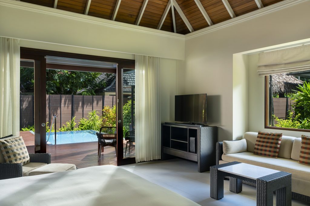 Hotelzimmer mit Bett, Sofa, Fernseher und Zugang zu privatem Pool und Garten auf den