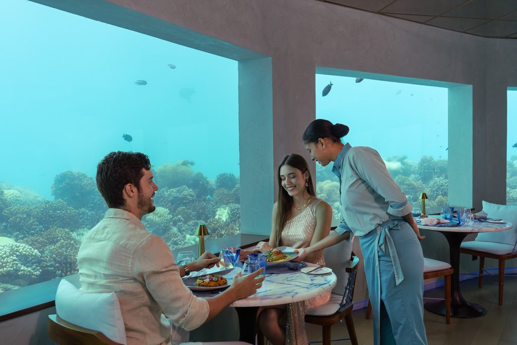 Unterwasserrestaurant Only Blu mit Panoramafenstern, Marmor­tischen und Holzmöbeln im OBLU SELECT Lobigili