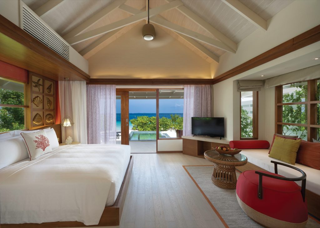 Zimmer der Sunnest Beach Pool Villa mit großem Bett, Holz- und Stoffwänden, Blick auf privaten Pool und Ozean