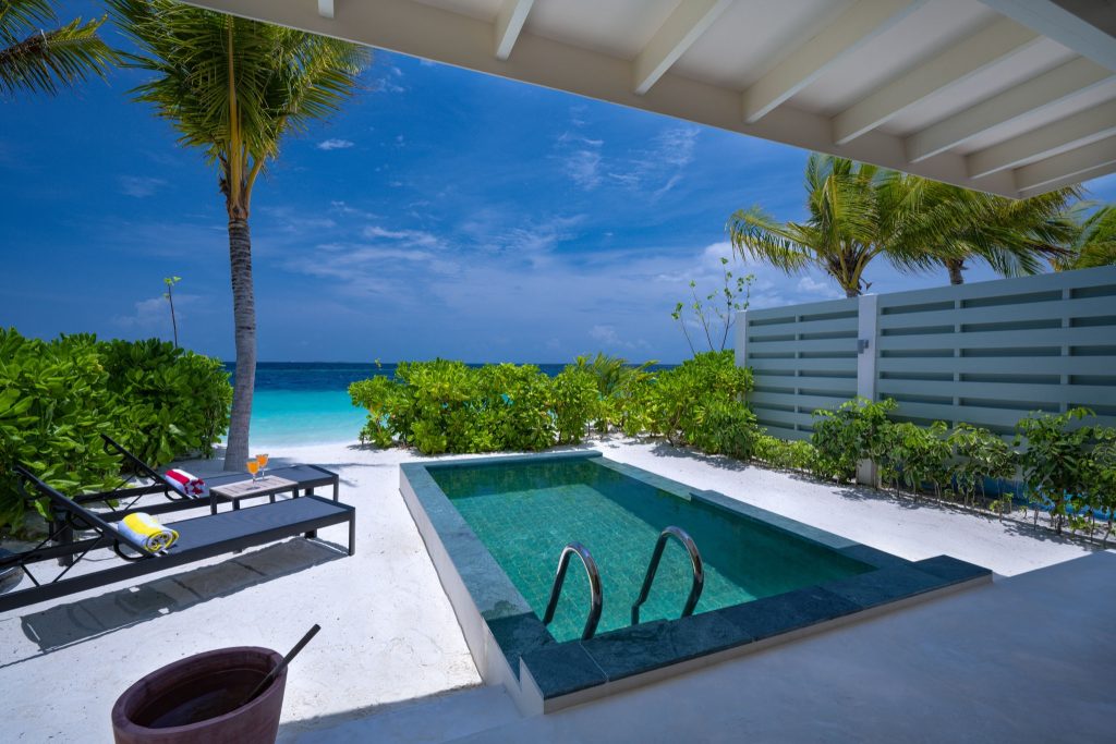Terrasse der Sunnest Beach Pool Villa mit zwei Liegestühlen, privatem Pool und Blick auf das Meer