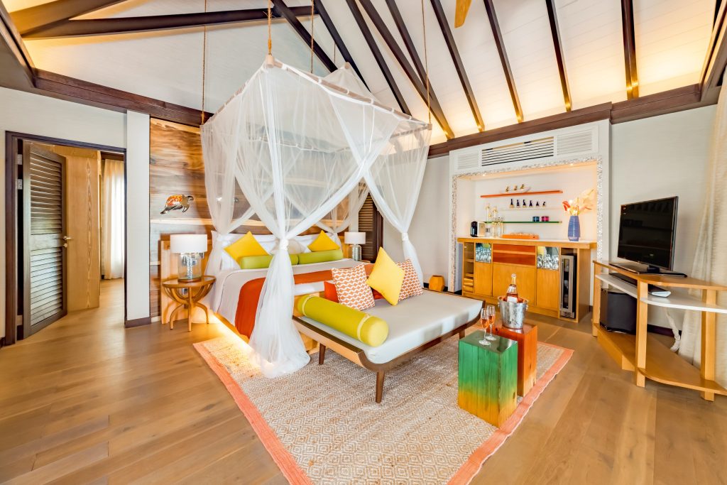 Hotelzimmer Earth Pool Pavilion mit Himmelbett, Holzboden und Deckenbalken im Ozen Life Maadhoo auf den