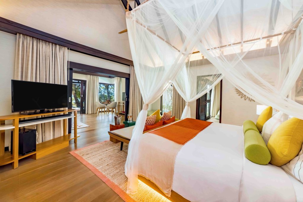 Modernes Zimmer im Ozen Life Maadhoo Earth Pool Pavilion mit Himmelbett, Holzfußboden und großflächigen Fenstern
