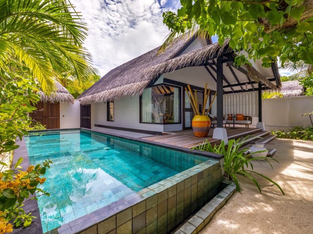 Earth Villa mit Strohdach, privatem Pool, Holzterrasse mit Lounge-Möbeln und großem Keramiktopf auf den