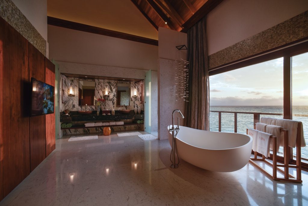 Badezimmer der The Ozen Residence im Ozen Life Maadhoo mit freistehender Badewanne und Meerblick durch große Fenster