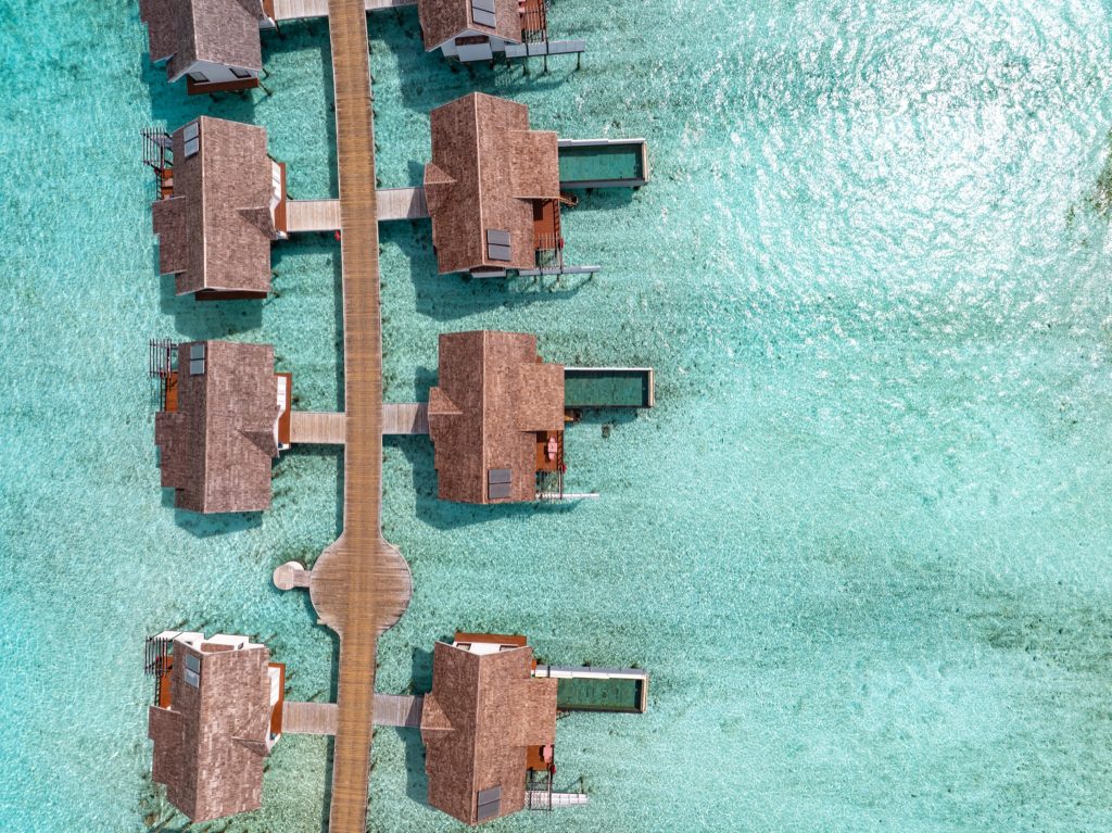 Luftaufnahme von Wind Villa with Pool im Ozen Life Maadhoo mit Holzbungalows über türkisfarbener Lagune