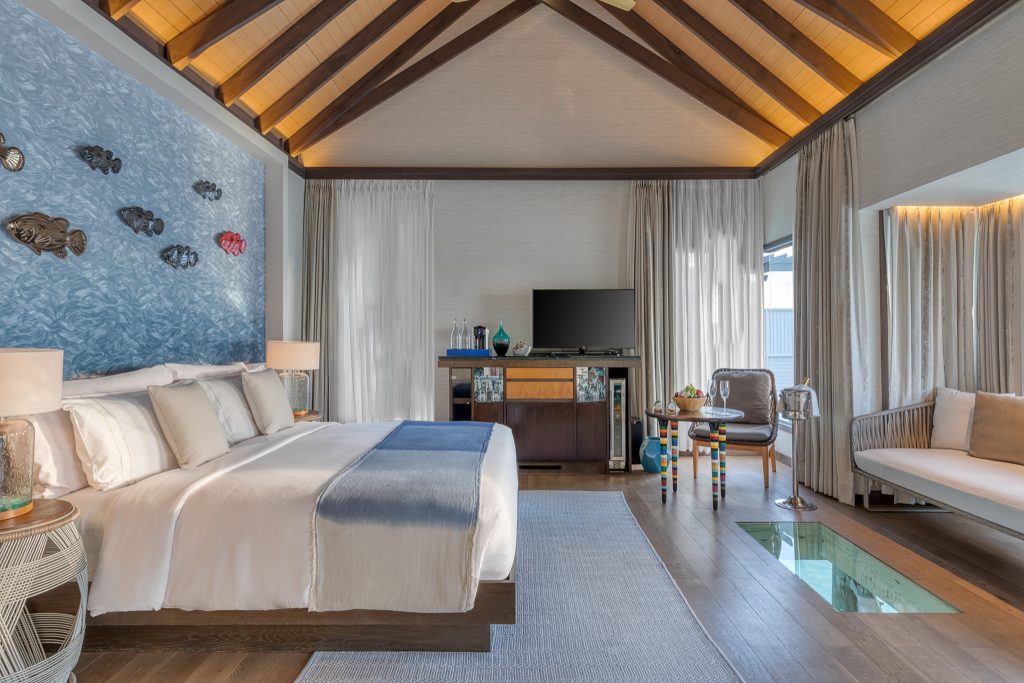 Hotelzimmer Wind Villa with Pool mit großem weißen Bett, blauer Metall-Wanddekoration, Holzboden und Glasbodenabschnitt