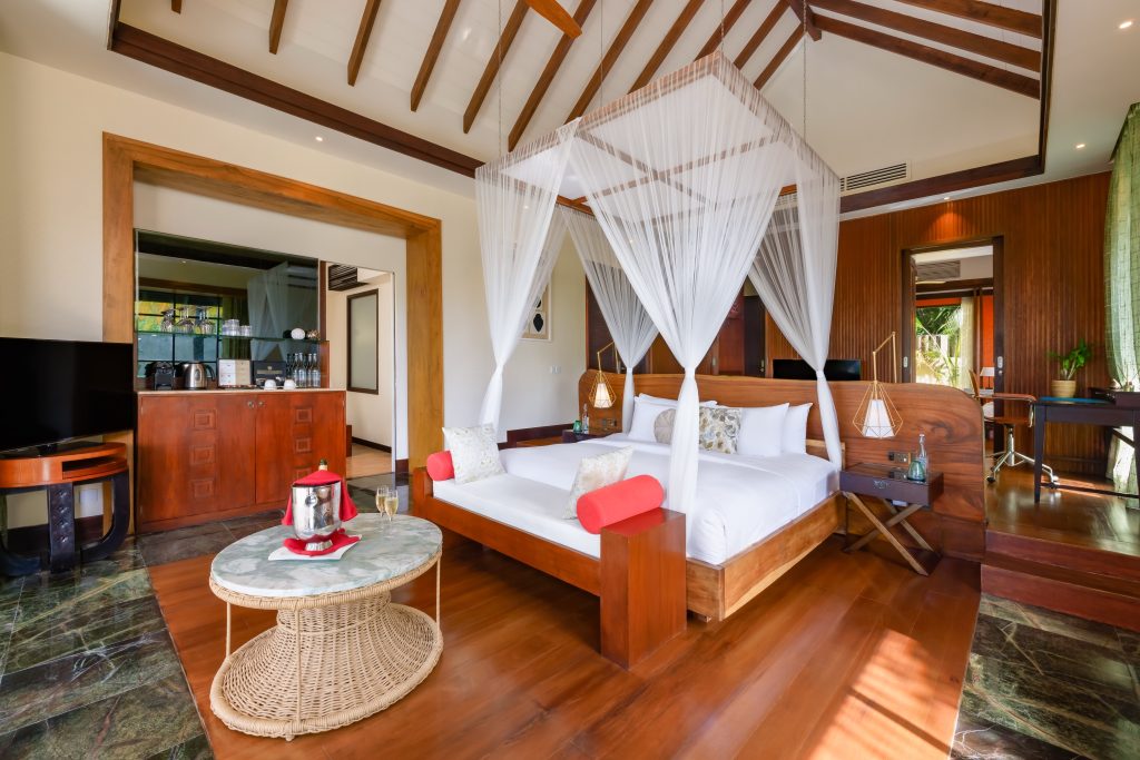Hotelzimmer Earth Pool Pavilion mit Himmelbett, Holzmöbeln, Marmor-Tisch und Tageslichtfenstern im Ozen Reserve Bolifushi