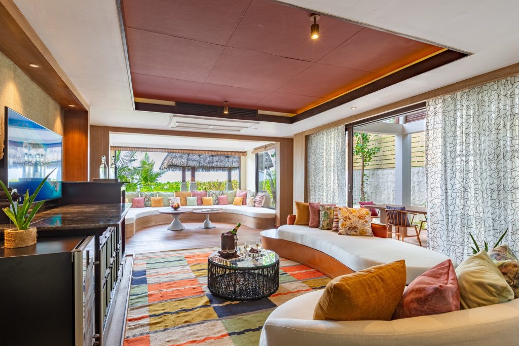 Offener Lounge-Bereich mit runder Couch, bunten Kissen, Holzboden und Glaswänden im Earth Pool Reserve Sunset 2BR