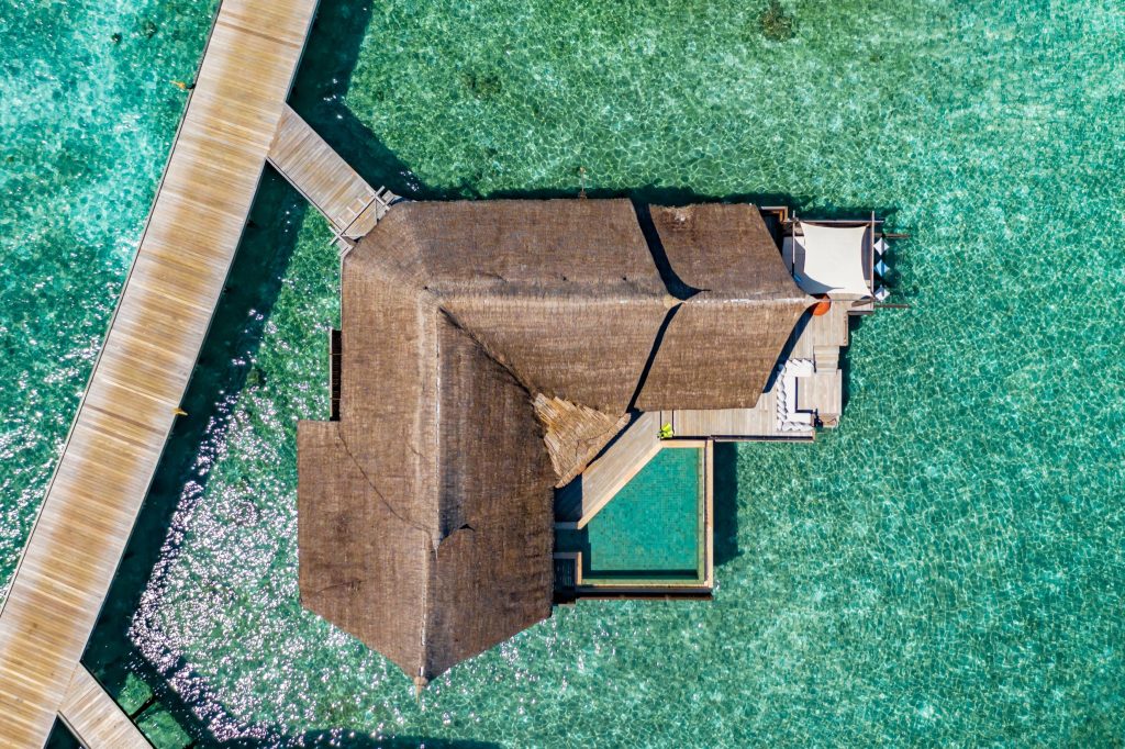 Luftaufnahme der Ocean Pool Suite im Ozen Reserve Bolifushi mit Holzterrasse, Strohdach und privatem Pool