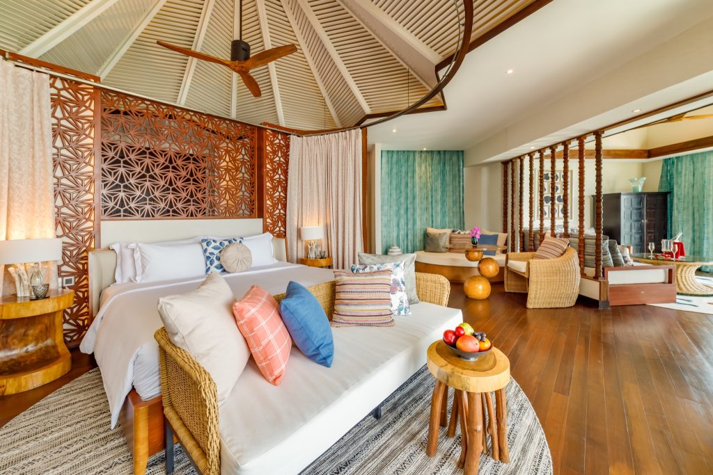 Ocean Pool Suite Schlafzimmer mit großem Bett, Holzmöbeln und Tageslicht in Ozen Reserve Bolifushi