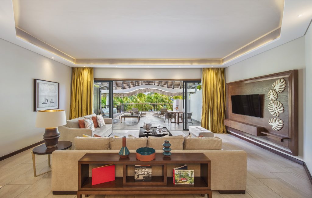 Penthouse Zimmer im Royal Palm Beachcomber Luxury mit Sofa, Holztisch, Sideboard und großem TV an der Wand