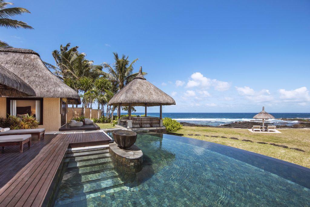Infinity-Pool mit Holzboden-Sonnenterrasse und tropischen Pflanzen im Shanti Maurice Resort & Spa