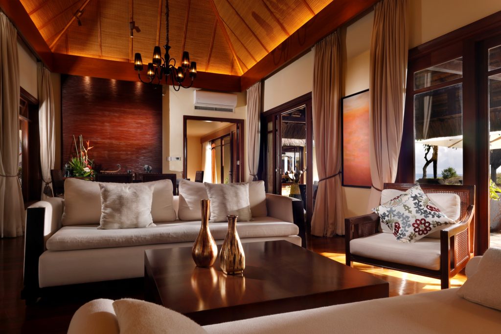 Wohnzimmer der Shanti Villa mit hohem holzgetäfeltem Dach, weißem Sofa und großen Fenstern
