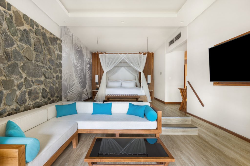 Deluxe Ocean View Room mit Himmelbett, Eckcouch, Natursteinwand und großem Flachbildfernseher