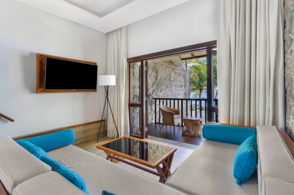 Deluxe Ocean View Room mit Sitzecke, beigen Sofas, Holztisch, Flachbildfernseher und Terrasse mit Meerblick