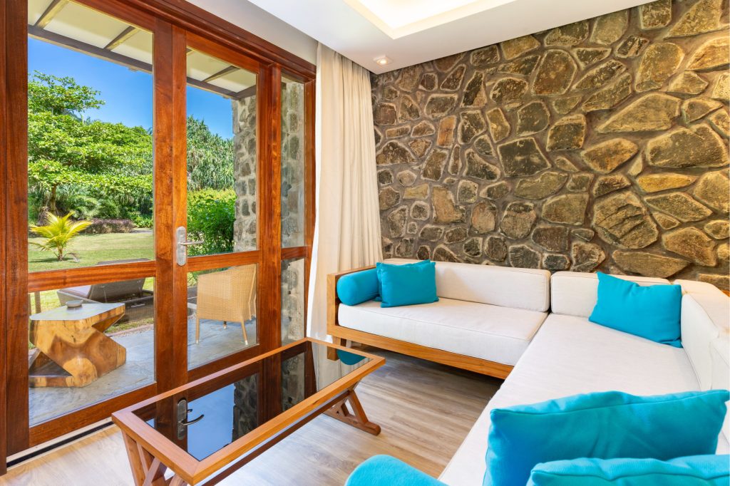 Hotelzimmer Superior Hill View Room mit großer Fensterfront und Blick auf Garten am Kempinski Seychelles Resort