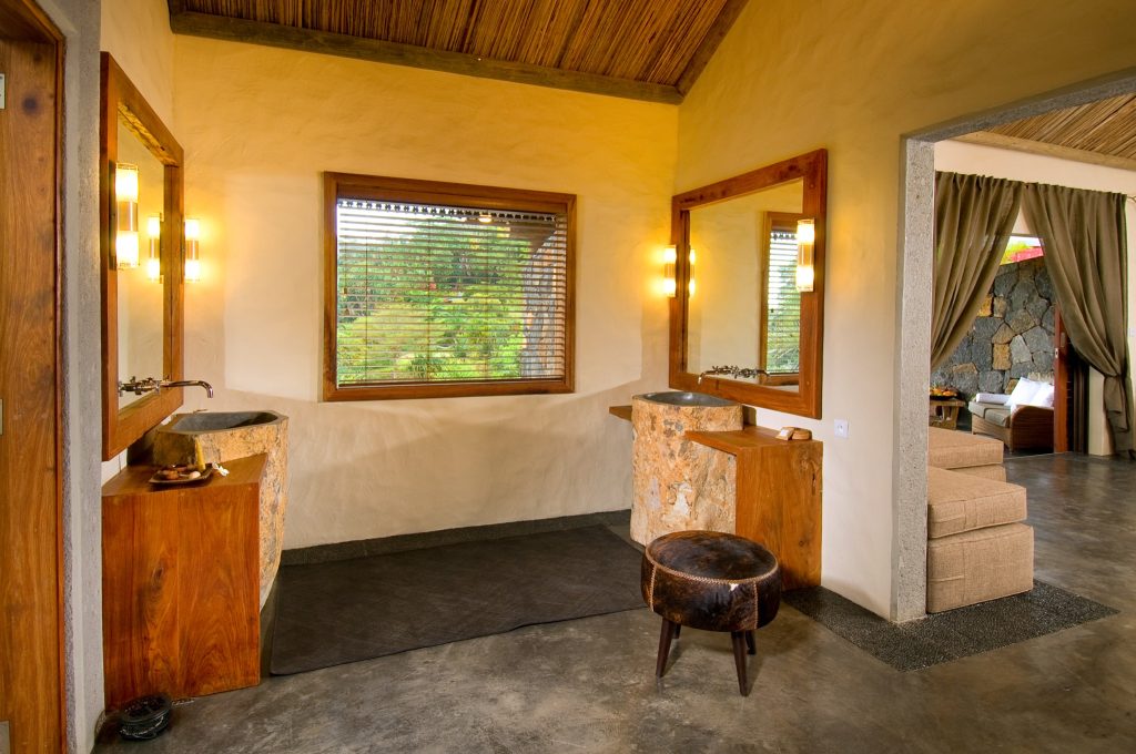 Hotelzimmer mit zwei Waschbecken auf Holzunterschränken, Holzdecke, Spiegeln und Fenster
