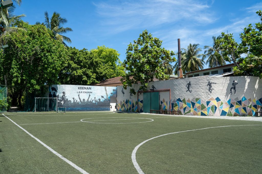 Sportplatz mit Kunstrasen und gemauerter Wand mit bunten Wandmalereien im Lily Beach Resort & Spa