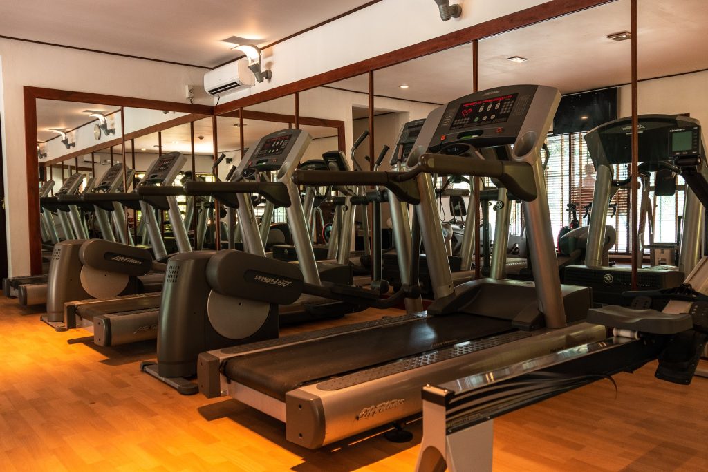 Fitnessraum im Lily Beach Resort & Spa mit mehreren Laufbändern, großen Spiegeln