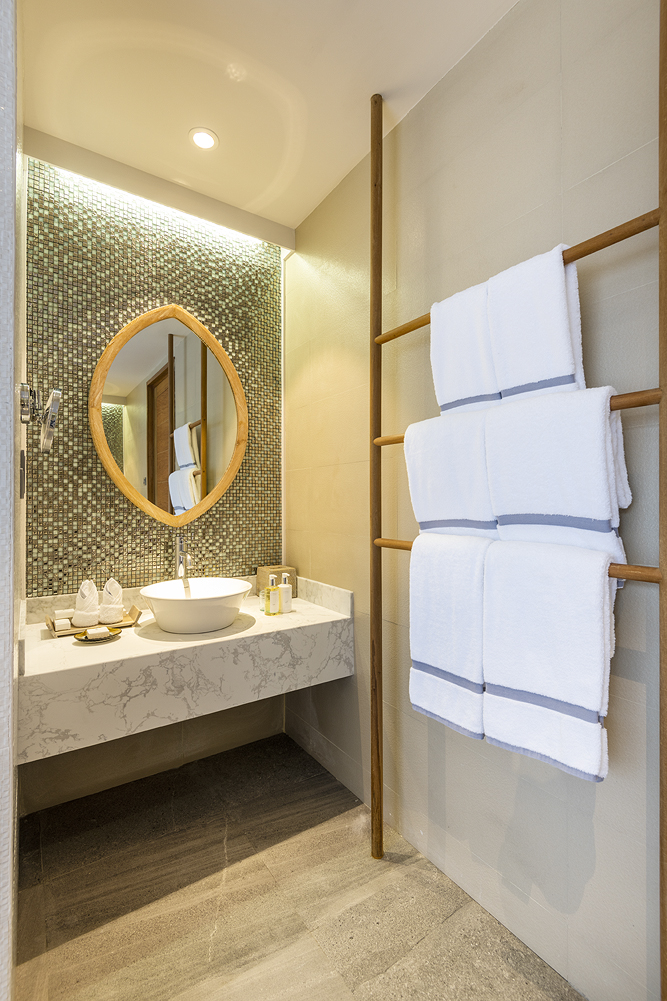 Modernes Badezimmer der Beach Residence im Lily Beach Resort & Spa mit weißem Marmorwaschtisch.