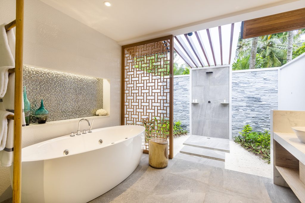 Badezimmer der Beach Suite im Lily Beach Resort & Spa mit freistehendem weißen Whirlpool