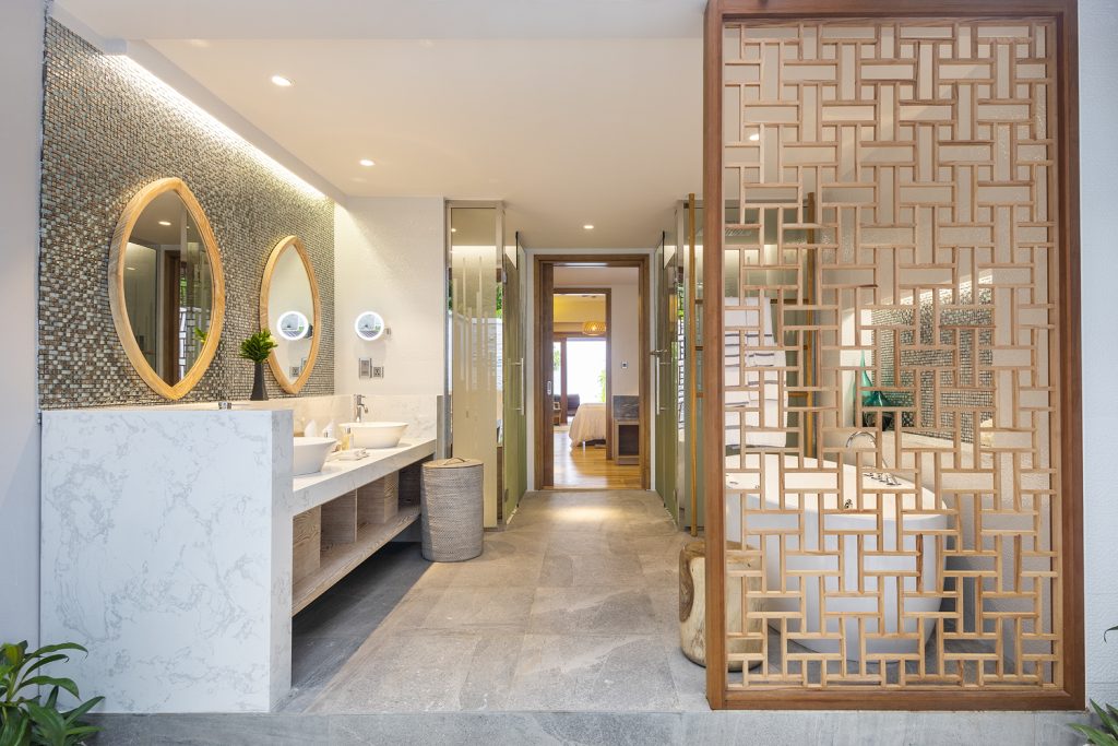 Modernes Badezimmer der Beach Suite mit Marmor-Waschtisch, zwei Waschbecken, Badewanne und Mosaikfliesenwand