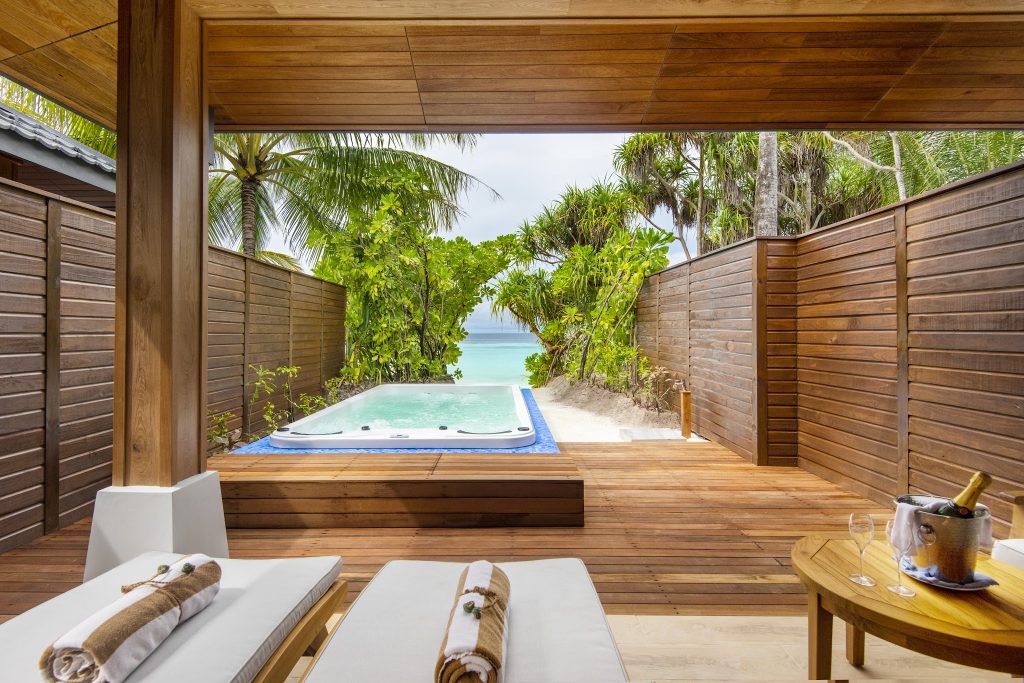 Private Terrasse der Beach Suite im Lily Beach Resort & Spa mit Holzplattform und Whirlpool mit blauem Rand