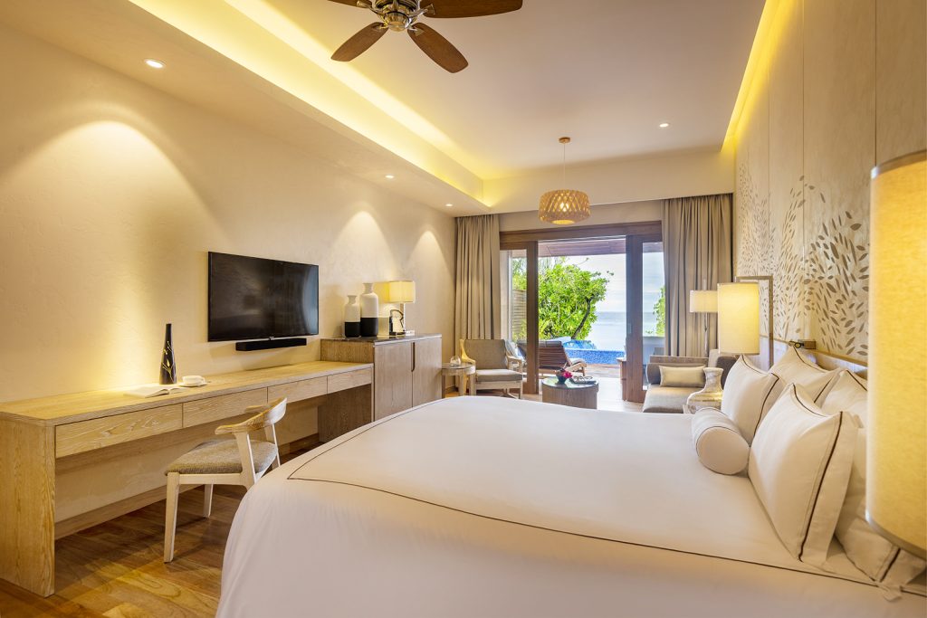 Geräumiges Hotelzimmer der Beach Suite mit großem Bett, Schreibtisch, Balkon und Meerblick im Lily Beach Resort & Spa