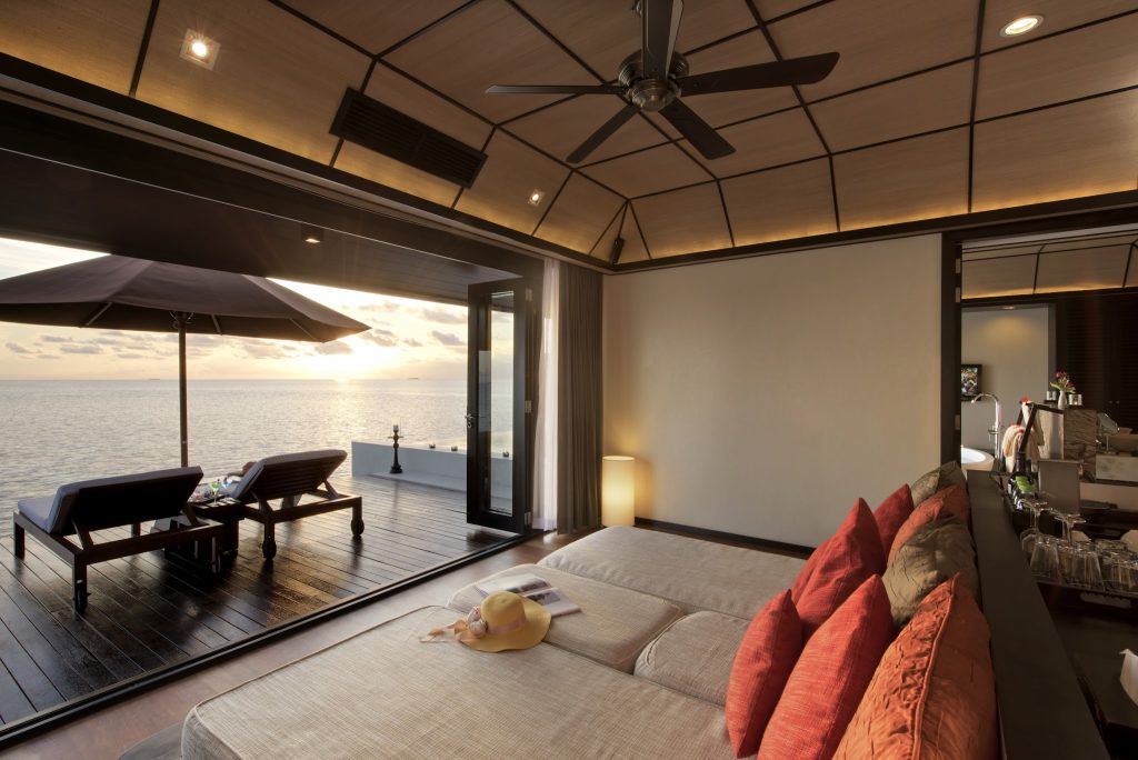 Zimmer der Water Suite im Lily Beach Resort & Spa mit Meerblick, großem Bett, Holzdecke und Terrasse
