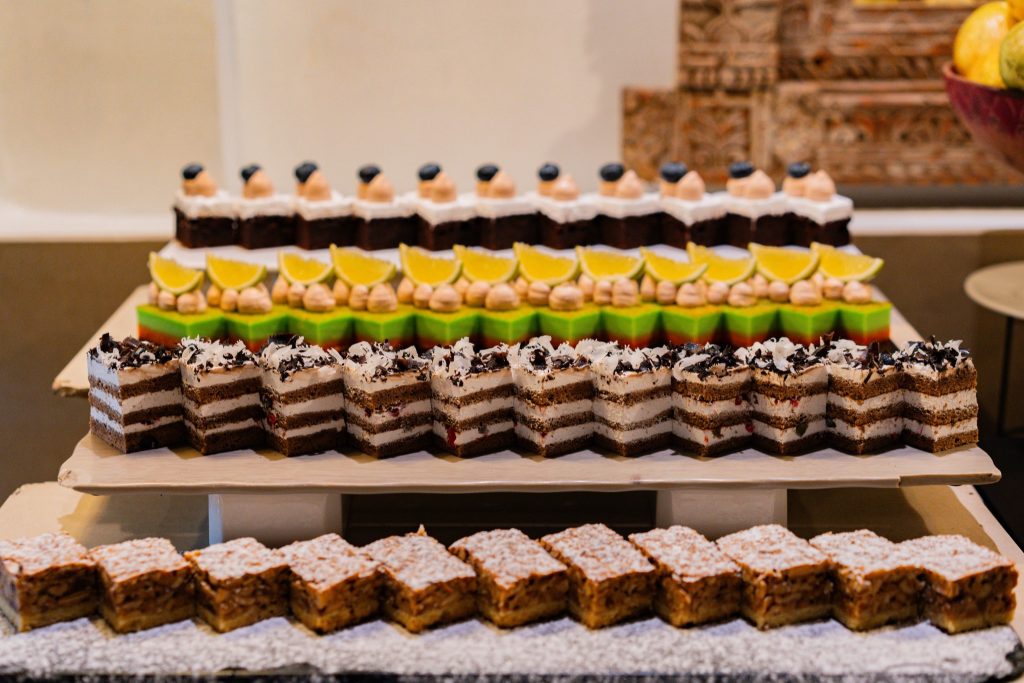 Nahaufnahme von mehreren Kuchenstücken mit Schokoladen-, Sahne- und Geleesorten auf Buffet im Neptune Pwani Beach Resort &.