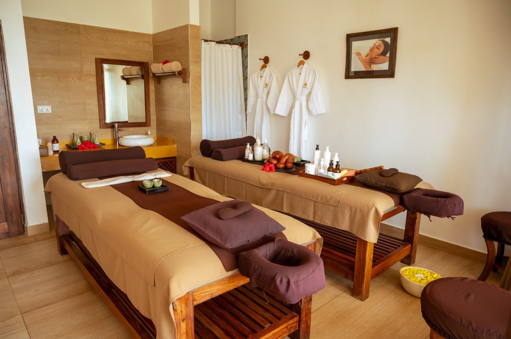 Spa-Zimmer im Neptune Pwani Beach Resort & Spa mit zwei Massagebetten, Waschbecken und Pflegeprodukten