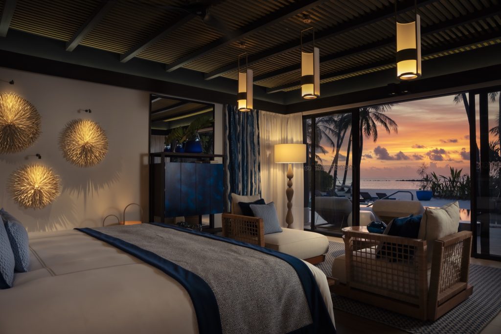 Restaurant Tavaru mit großen Glasfenstern, Sonnenuntergang, Holzmöbeln und Sitzkissen auf Velaa Private Island