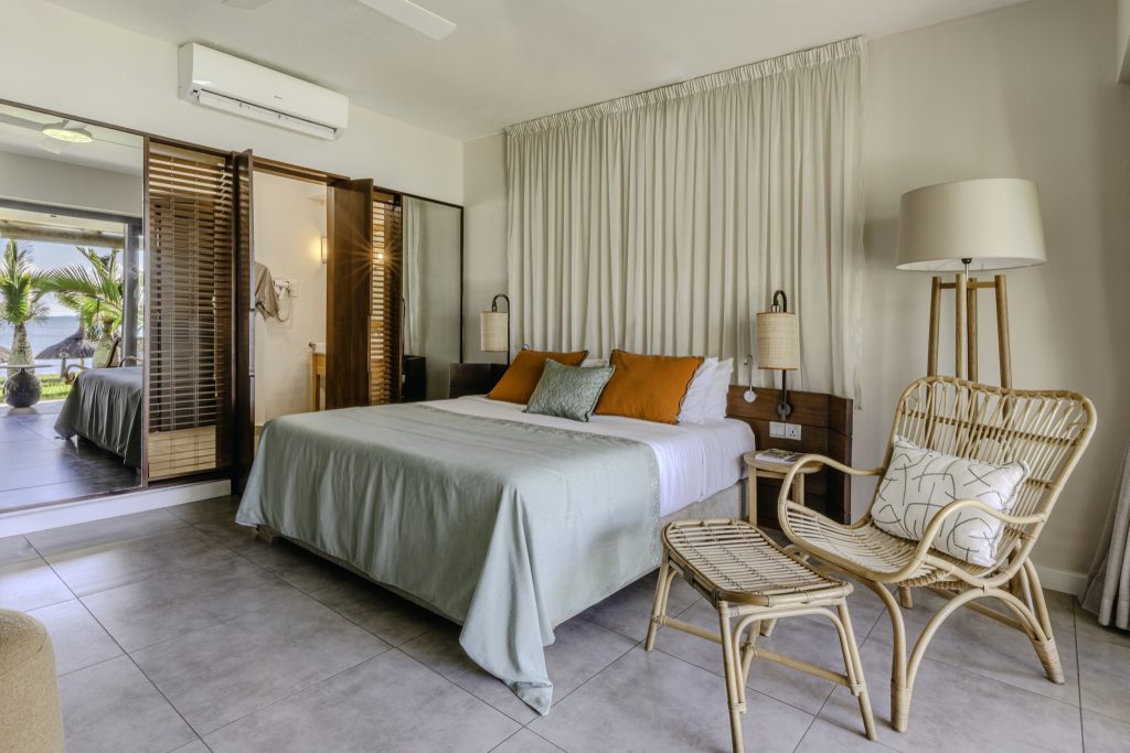 Modernes Superior Room im Veranda Paul et Virginie mit Doppelbett, Rattansessel, Holzlamellen-Schiebetür und Tageslicht