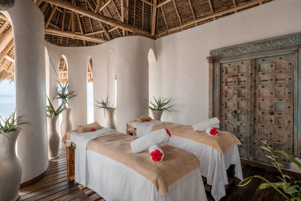 Heller Wellnessraum im Xanadu Villas Kiota Spa mit zwei Massageliegen, weißen Wänden, Holzboden und Meerblick