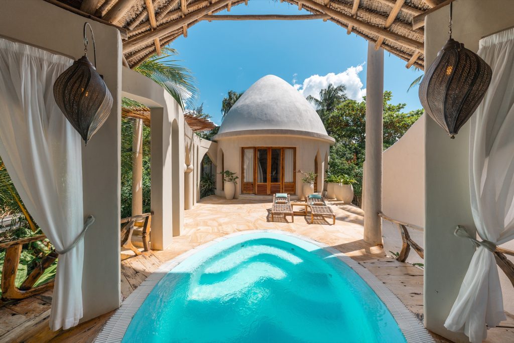 Terrasse der Villa Mawimbi in Xanadu Villas mit kleinem Pool, Holzliegestühlen und kuppelförmigem Dach