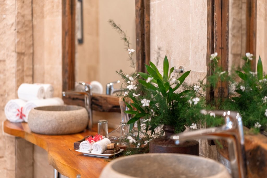 Badezimmer der Villa Mawingu mit hölzerner Ablage und steinernen Waschbecken in Xanadu Villas