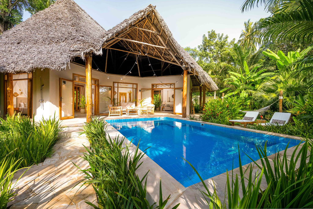 Poolbereich im Zanzi Resort mit klarem Wasser, offenem Holzpavillon und tropischen Pflanzen im Hintergrund