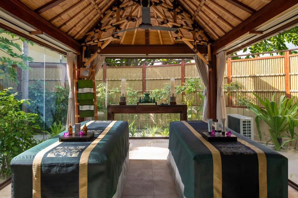 Spa-Raum im Banyan Tree Vabbinfaru mit zwei Massagebänken, Holzdecke, Bambuswänden und großen Glasfenstern