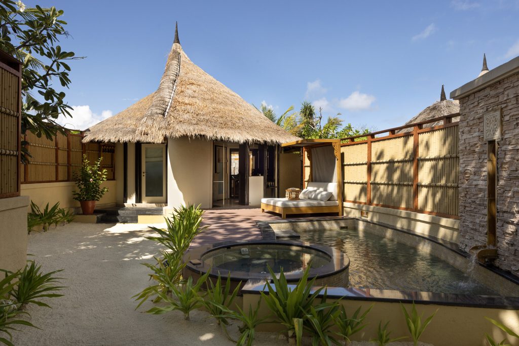 Strohgedeckter Bungalow mit privatem Pool aus Holz, Stroh und Stein bei Tageslicht im Banyan Tree Vabbinfaru