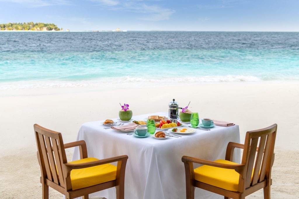 Gedeckter Frühstückstisch im Restaurant Dhawa Ihuru am Strand mit Meerblick, Croissants, Obst und Kaffeezubereiter