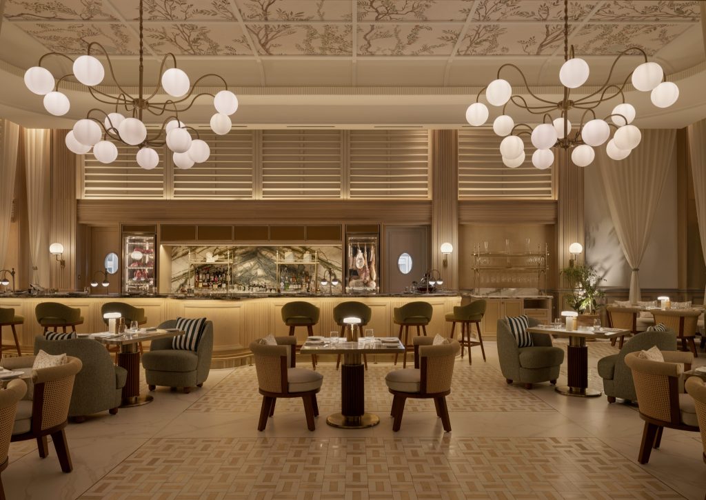 Hotelrestaurant mit offenem Barbereich, hellem Holz, Marmorwand, Kronleuchtern und Sitzmöbeln