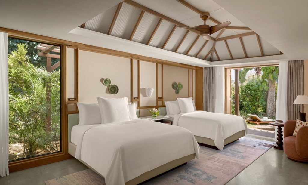 Hotelzimmer mit zwei Doppelbetten, großen Fenstern und Blick auf einen bepflanzten Garten im Four Seasons Resort Mauritius.